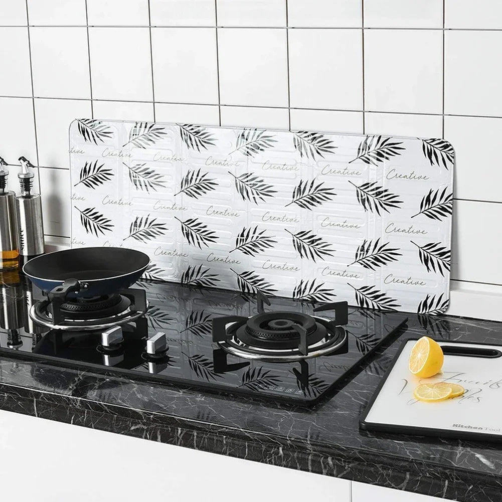 Kitchen stove baffle made of foldable aluminum foil featuring a tropical leaf pattern. This splash guard and cooking safety screen is perfect for deep frying and adding a touch of style to your kitchen decor. Use it as stove top protectors for added