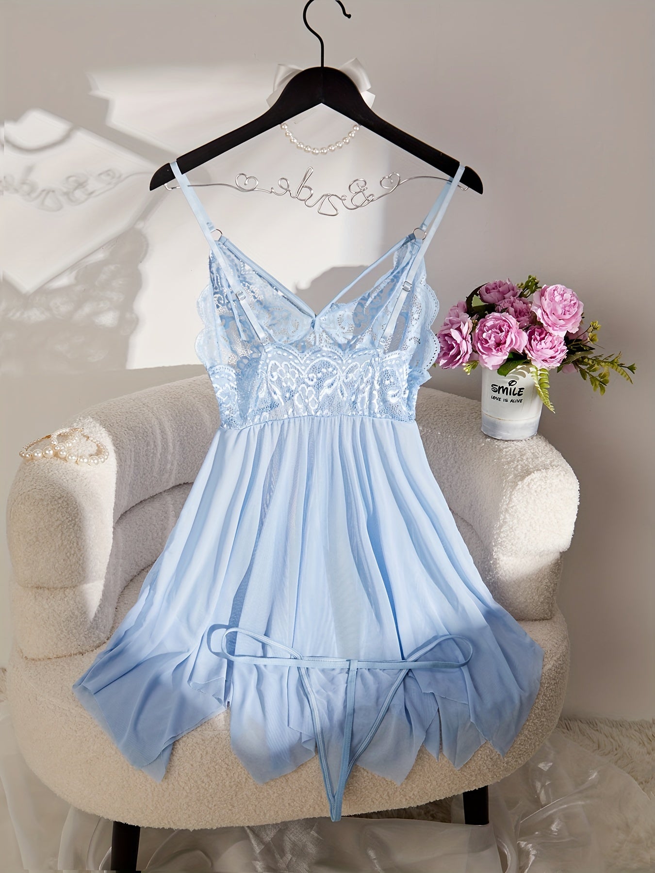 Feminine lace and sheer slip dress set with matching thong, perfect for special occasions and intimate moments. Features V-neck with ruffle detail, made of polyester blend, and hand