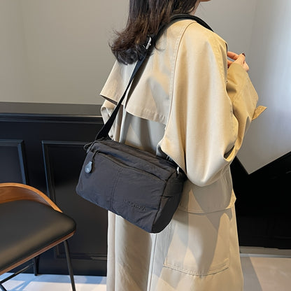 Stylish nylon crossbody bag for women: spacious, lightweight, versatile solid color with zip closure, ideal for everyday use. Available in khaki/black.