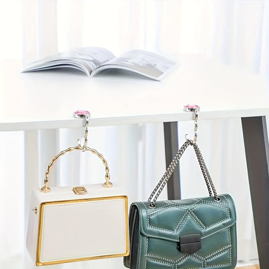 Hang your purse securely on desks in cafes, libraries, and more with the Portable Foldable Handbag Hook.