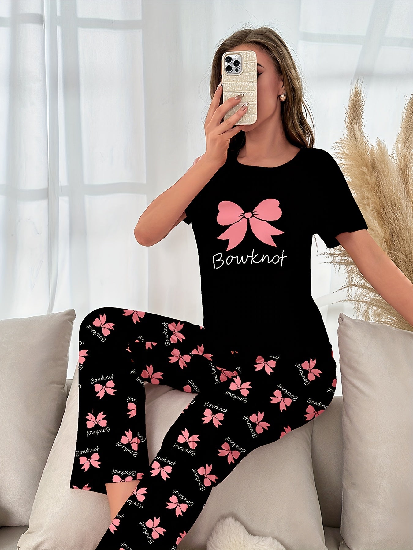 Women's sleepwear set with bow & slogan print, short sleeve top, and elastic pants.