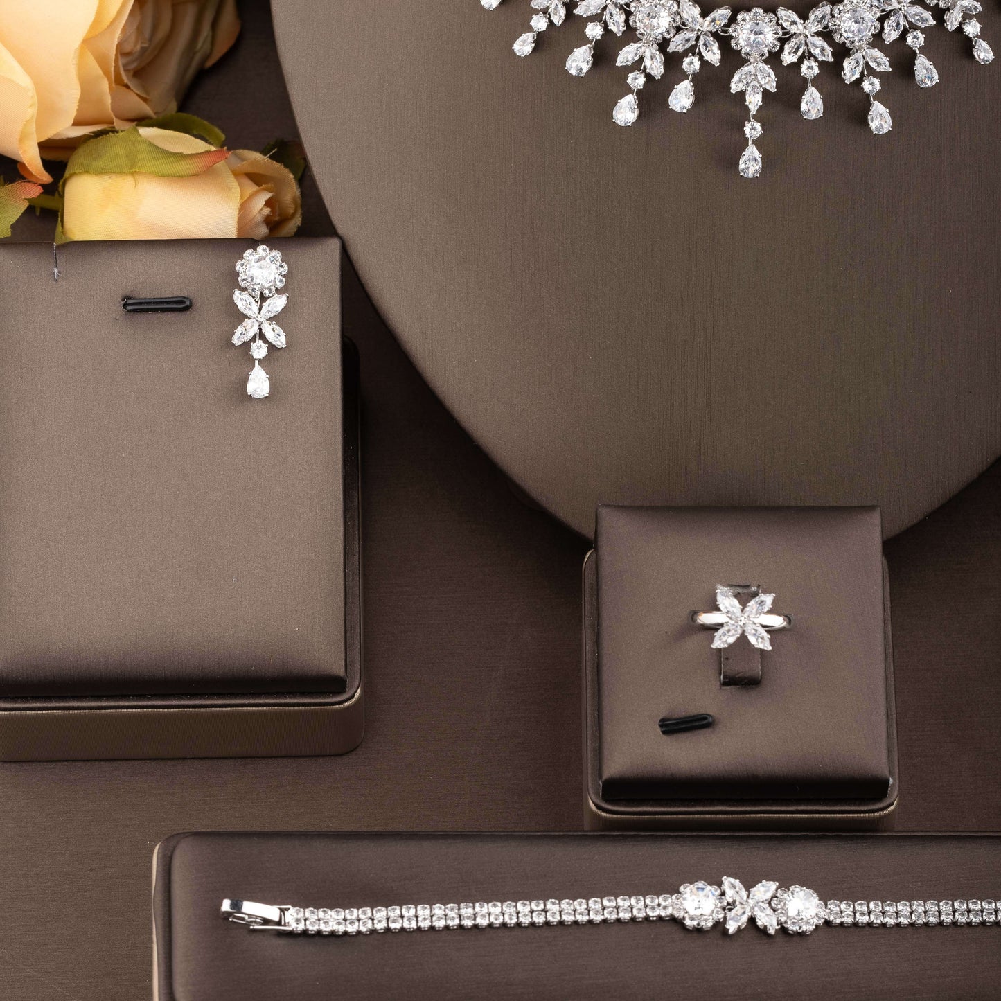 Beautiful wedding jewelry ensemble featuring intricate floral design with dazzling cubic zirconia stones, crafted in luxurious 18K gold plated copper. This set includes a necklace, earrings, bracelet, and ring, perfect for both bridal wear and special