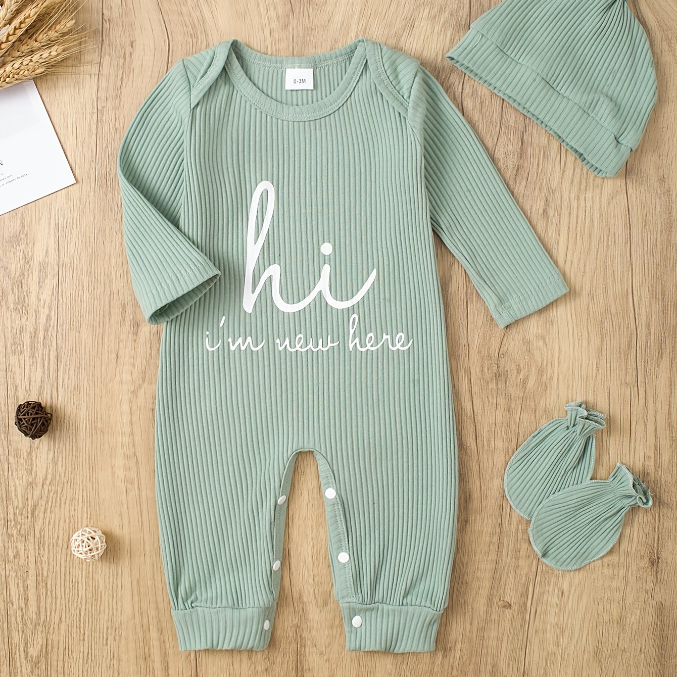 Newborns' "Hi I'm New Here" outfit: long-sleeve romper, hat, and gloves for boys and girls for outdoor wear.