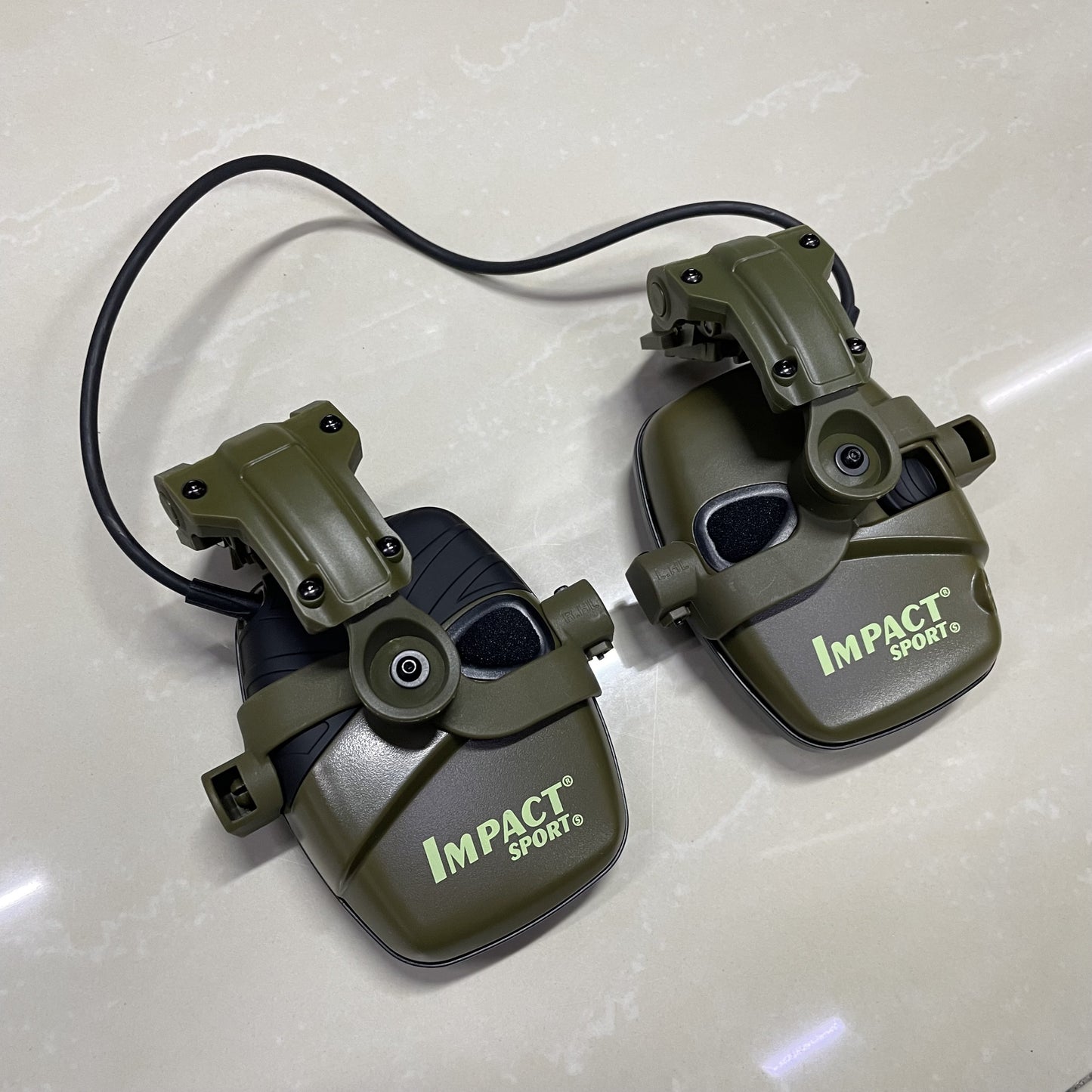 Helmet-mounted tactical shooting earmuffs with electronic sound pickup, active noise reduction, and no battery requirement.