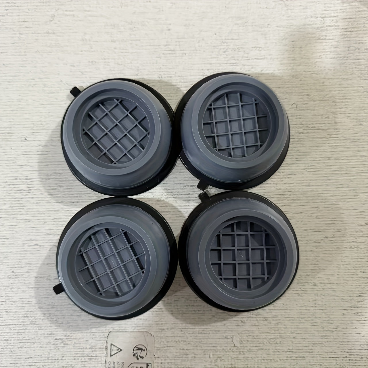 Four large anti-vibration pads made of durable plastic material dampen shock and cancel noise for washing machine stability, reducing vibration and noise.