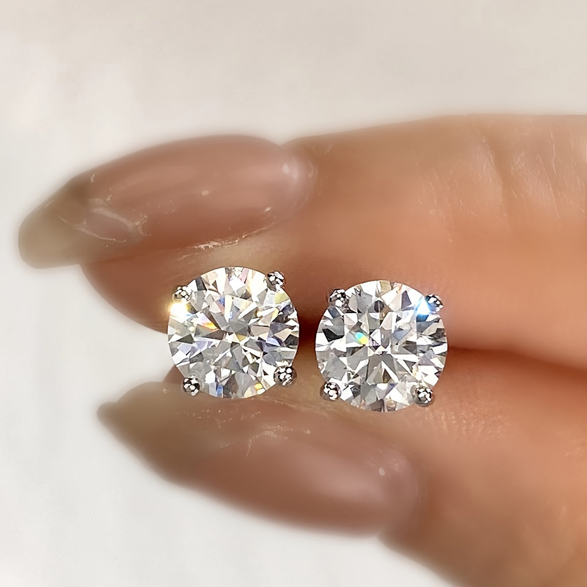 These elegant moissanite earrings come in a pair with a simple four-prong design weighing 1.2 grams for 0.5 carats, 1.7 grams for 1 carat, and 2.5 grams for 2 carats. Perfect for daily wear, these exquisite high-end ladies' jewelry pieces make a stunning