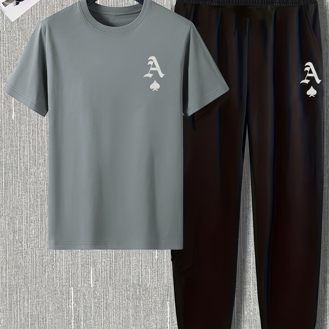 Men's casual sports set with short sleeve round neck t-shirt and regular fit pants, made of polyester and spandex blend for breathability and stretch. Printed logo on shirt.