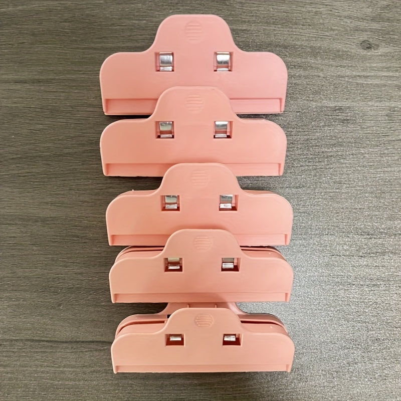 Set of 5 ABS Plastic Bag Clips in various colors for large, durable sealing in the kitchen. Keep snacks fresh with these beige, pink, light gray, and dark blue/black clips.