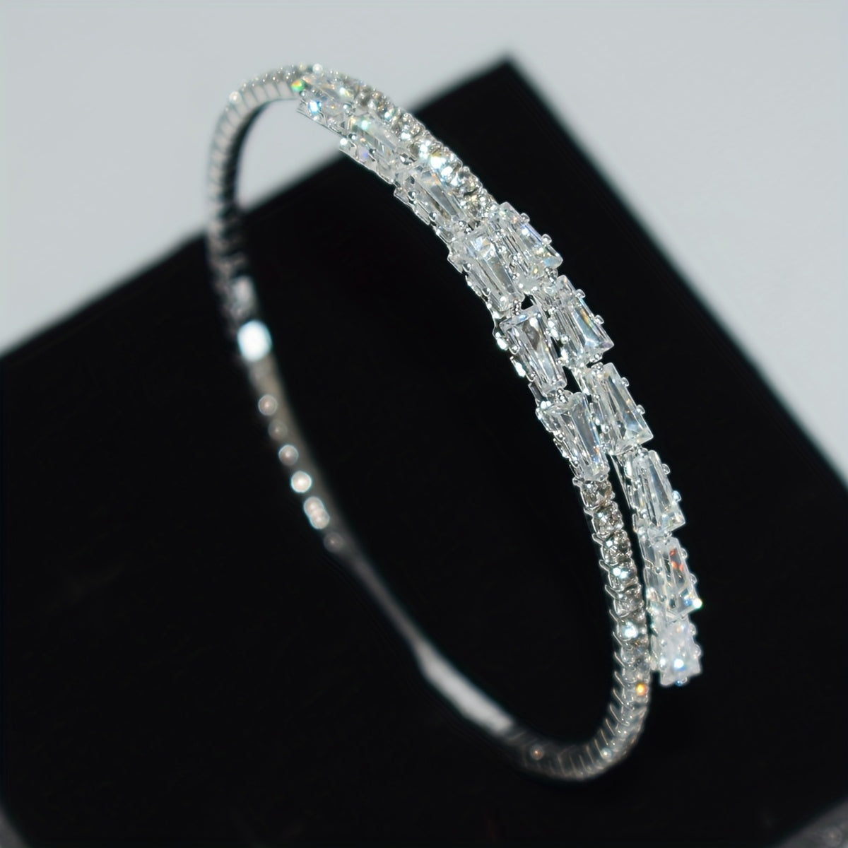 Elegant silvery-plated bracelet with cubic zirconia in classic single row design for weddings and everyday glam.