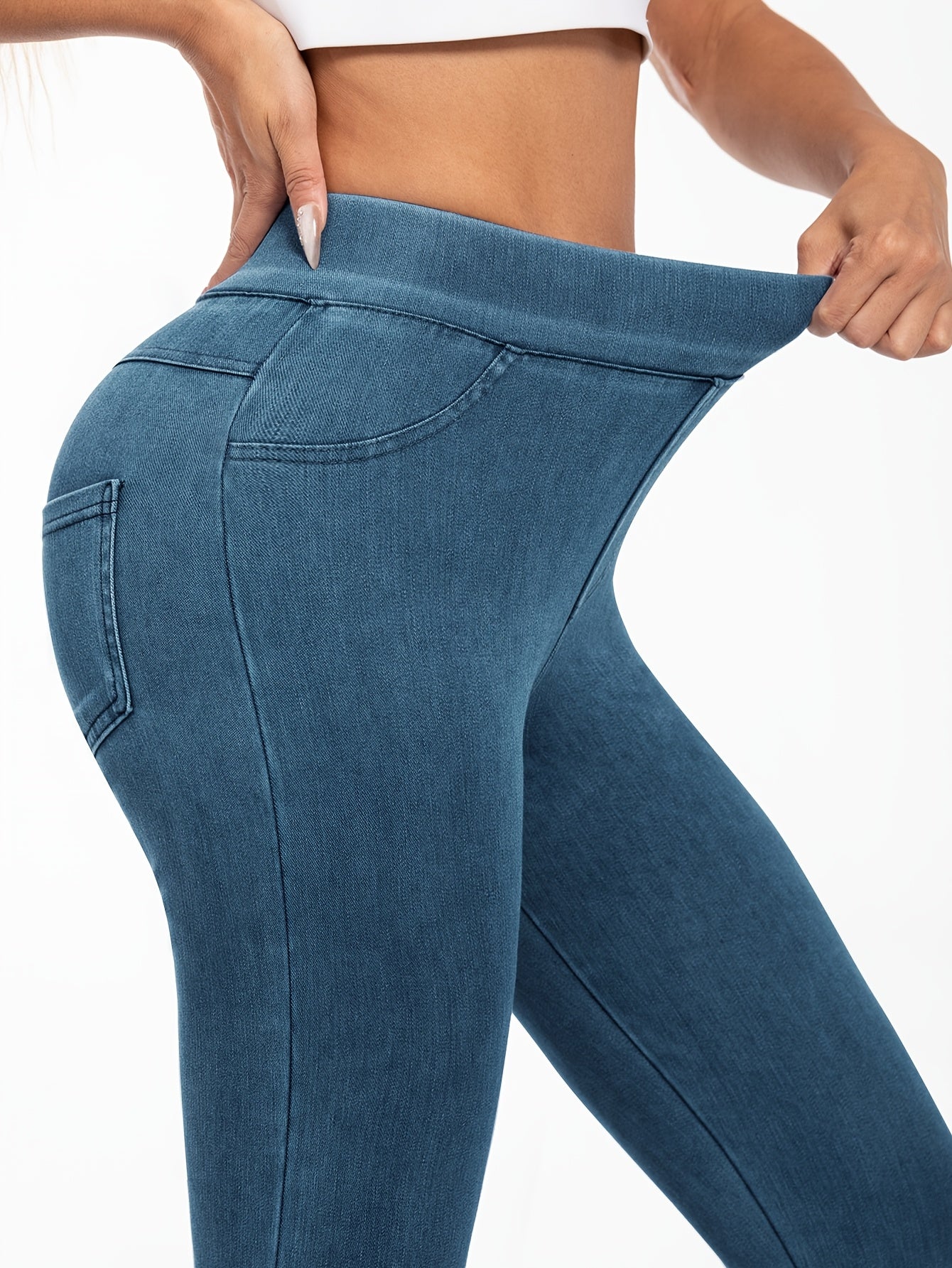 Women's high-waist faux denim jegging with elastic band and pockets. Polyester spandex blend for medium support. Solid color, woven fabric, cropped length. Suitable for everyday wear.