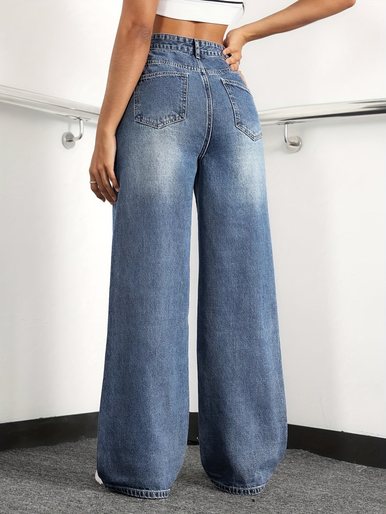 Women's wide leg jeans with high waist and washed details, suitable for casual fashion.