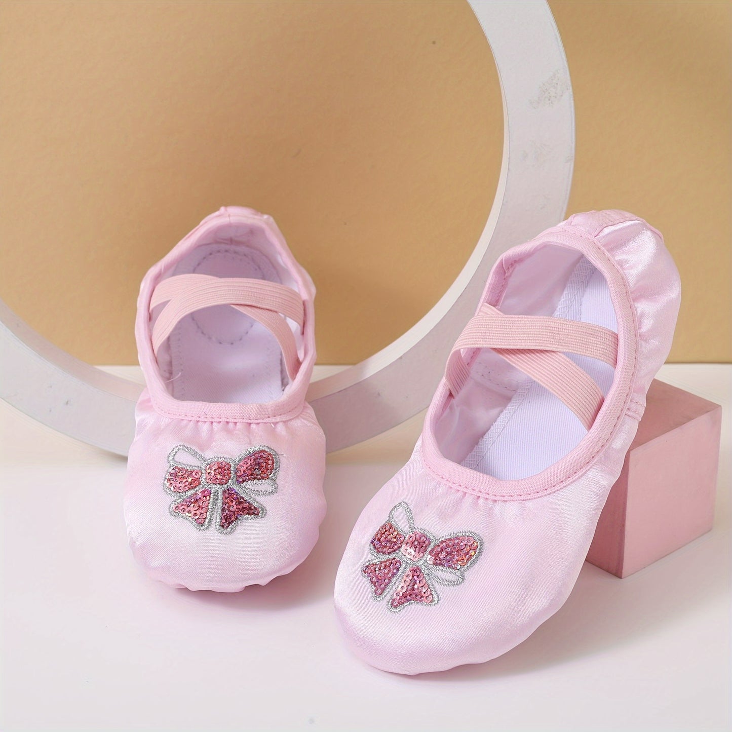 Girls’ ballet dance shoes with sparkling sequin and embroidered bow detail, soft sole, breathable canvas slip-ons. Available in pink and peach.