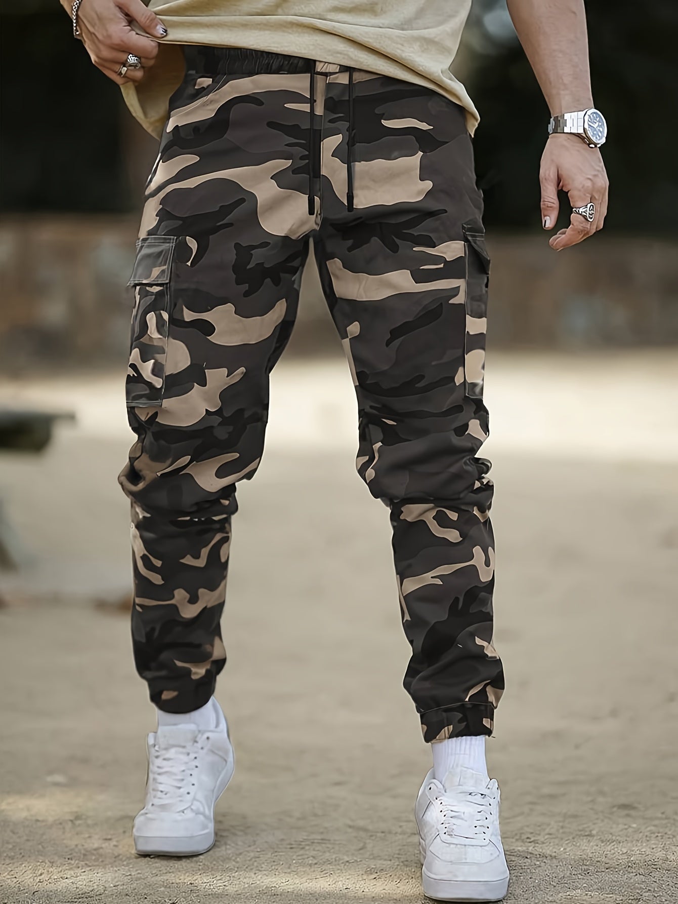 Men's camo cargo pants made from 100% non-stretch polyester fabric with a drawstring waist and flap pockets. Suitable for outdoor work.