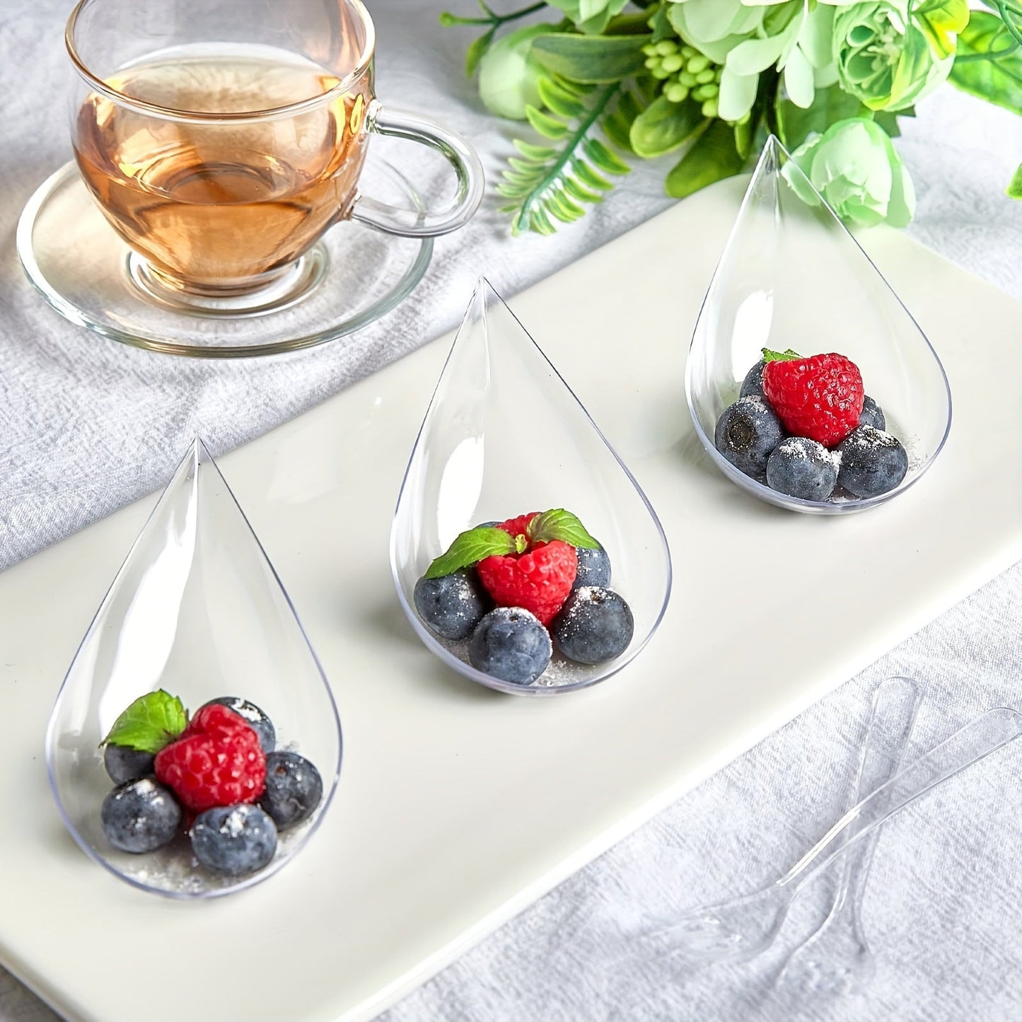 This set includes 50 Tear Drop Appetizer Spoons made of clear plastic, each measuring 4 inches. They are perfect for serving desserts and hors d'oeuvres. These BPA-free and recyclable spoons are ideal for special occasions such as Christmas, Halloween