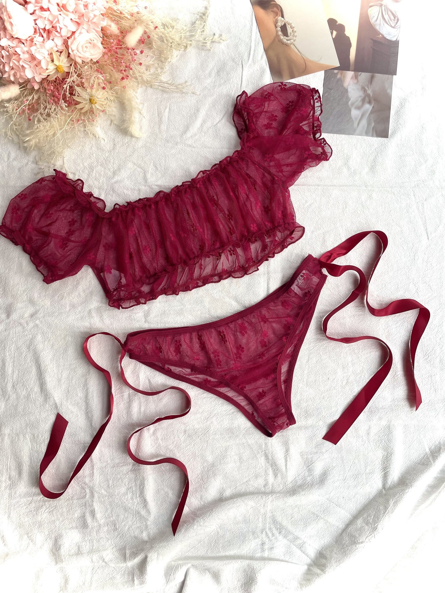 Red lace lingerie set with off-shoulder bra and low-rise panties for women.