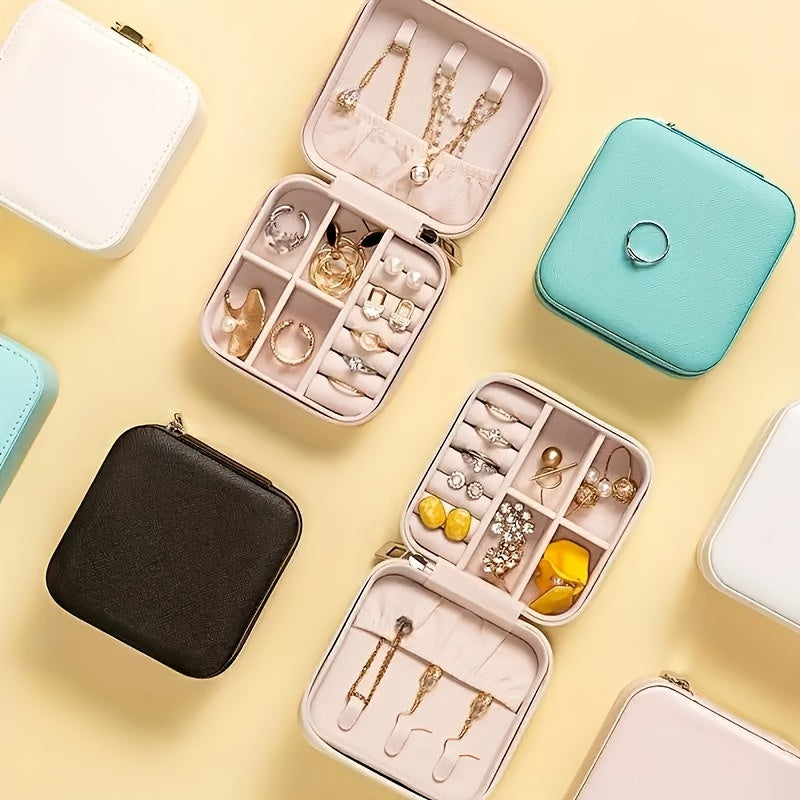 Compact waterproof PU jewelry organizer with removable dividers for rings, necklaces, and earrings. Portable and multi-functional with a zipper closure. Ideal for travel, available in white, teal, and black.