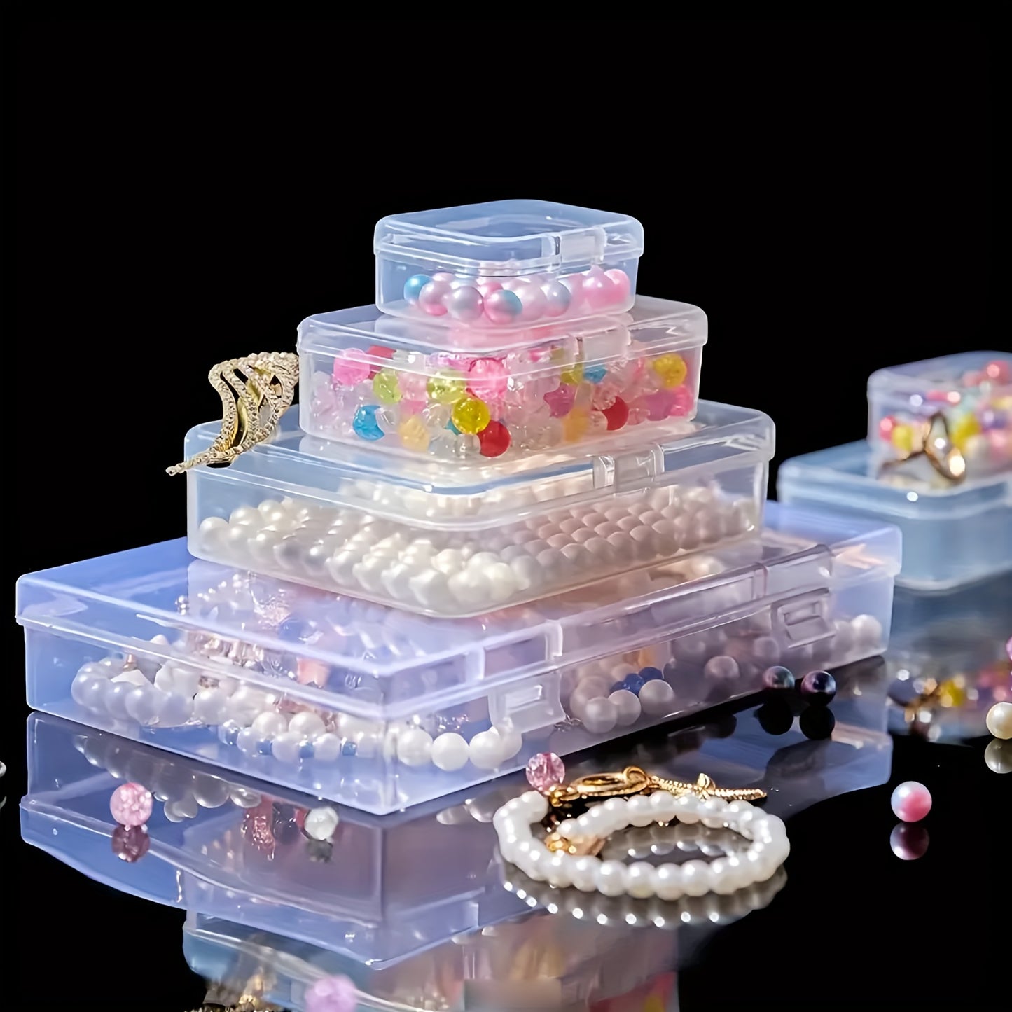 Clear plastic storage boxes with hinged lids in assorted sizes for organizing jewelry, beads, office supplies, and games.