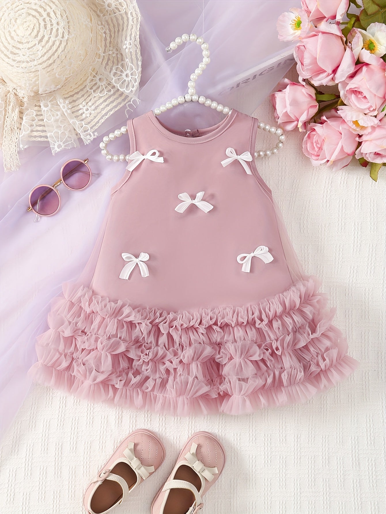 Infants' pink tulle dress with white bow accents, sleeveless, crew neck, asymmetrical hem, 100% polyester, casual midi dress for spring/fall.