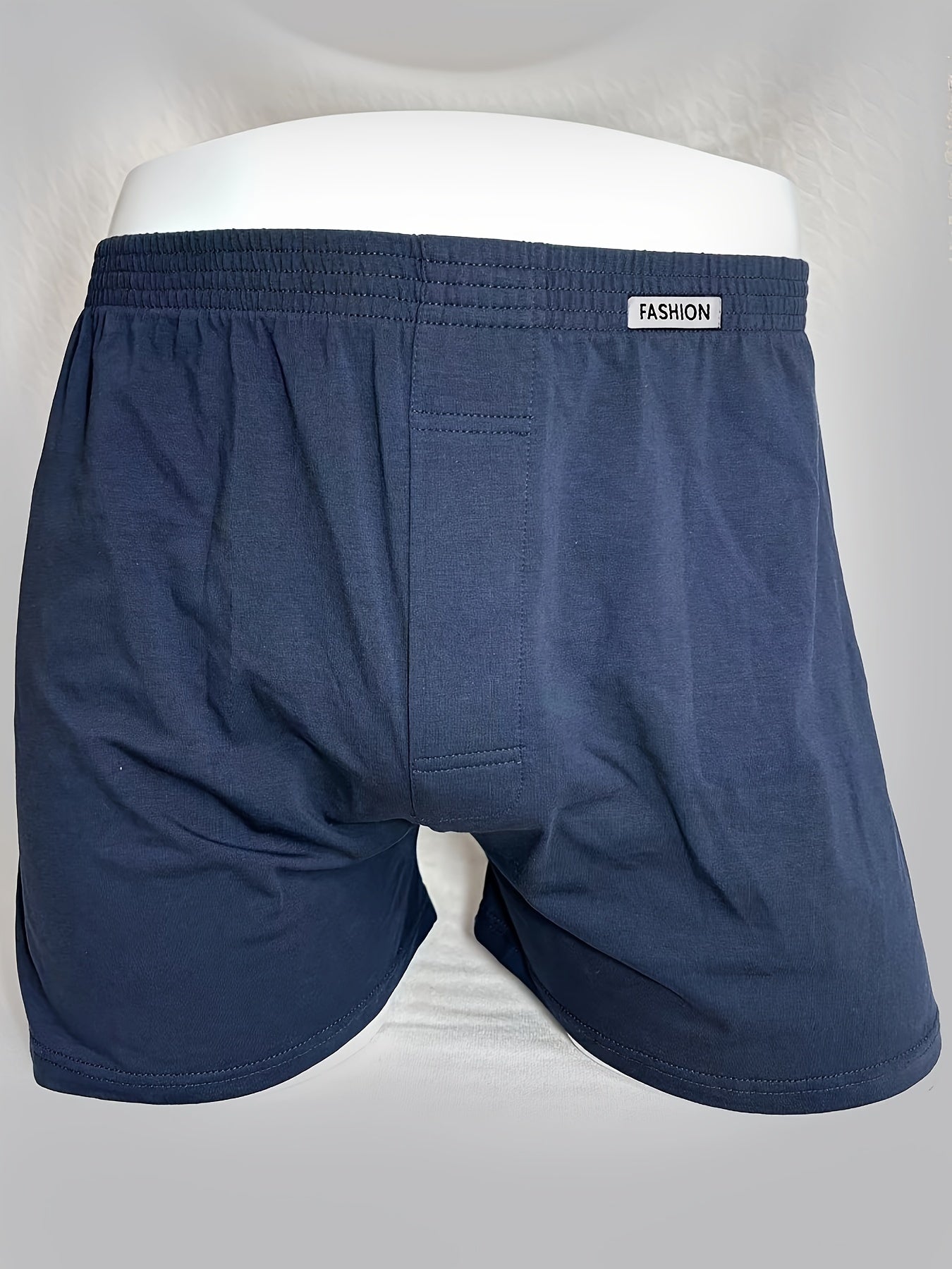 Three men's cotton boxer briefs in black, navy, and light blue with elastic waistband and no-ride design.