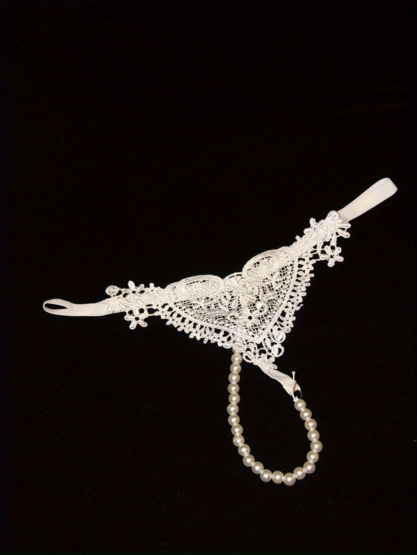 Low-rise thong with pearl embellishments and hollow out design. Breathable polyester, hand washable. Ideal for adults.