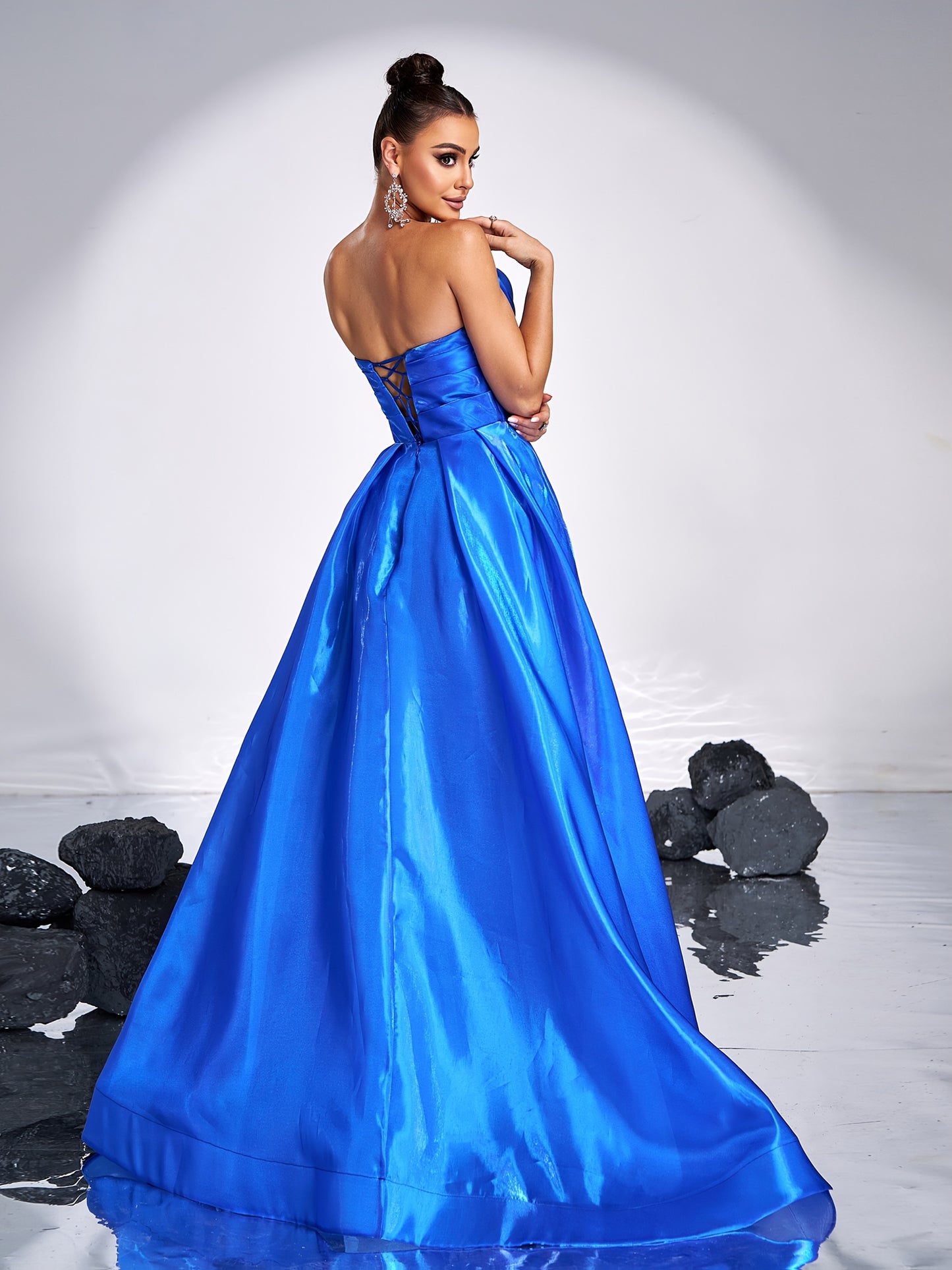 Elegant royal blue satin tube dress with rhinestone detailing and backless design, perfect for parties and formal events. Off-shoulder gown with flowing skirt and structured silhouette.