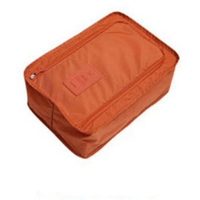 Orange shoe storage bag with mesh front pocket, zippered closure, lightweight material for neat shoe organization.