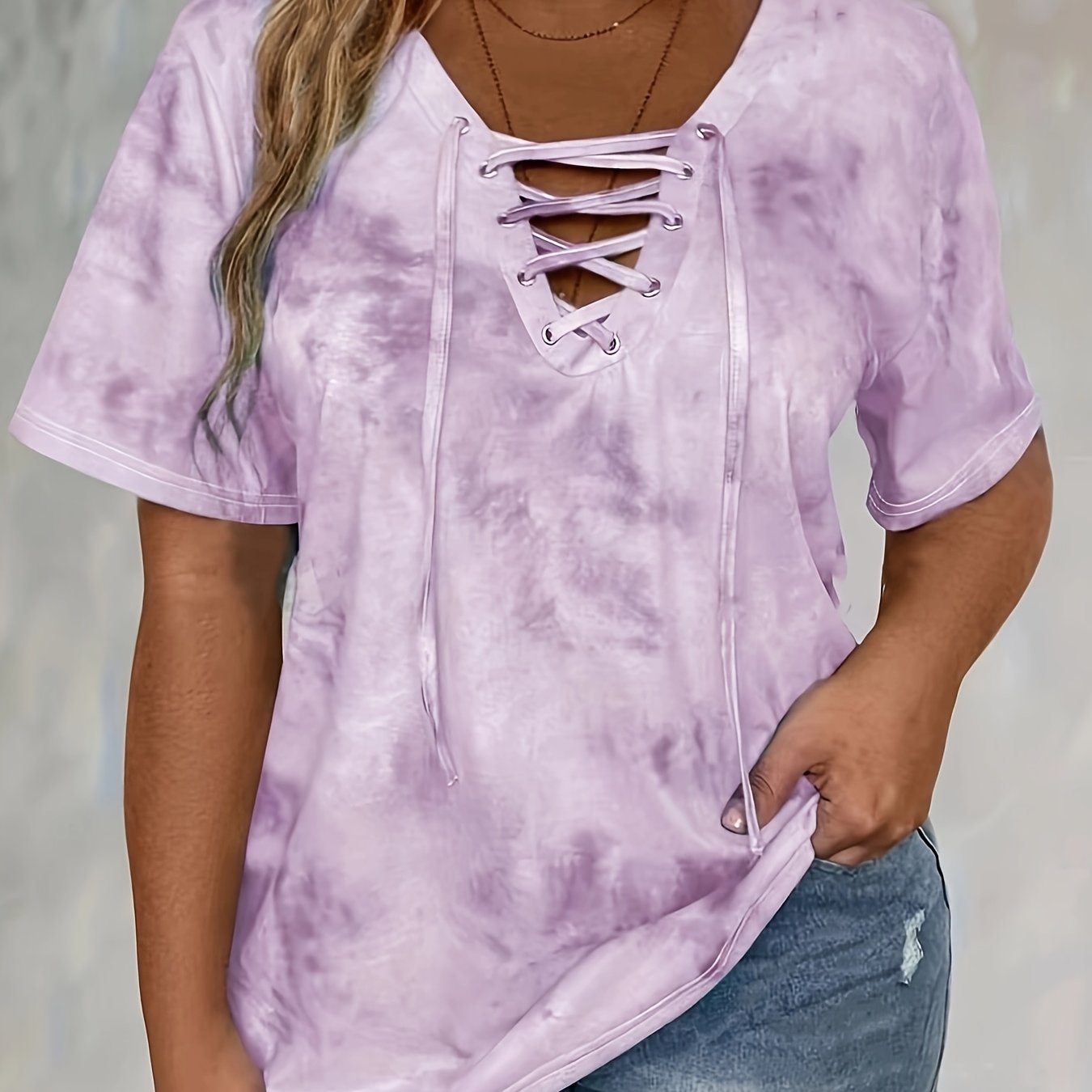 Plus size tie dye print t-shirt for women, made of polyester knit fabric with spandex. Features a lace-up drape neck detail and medium stretch. Ideal for spring/summer casual wear.