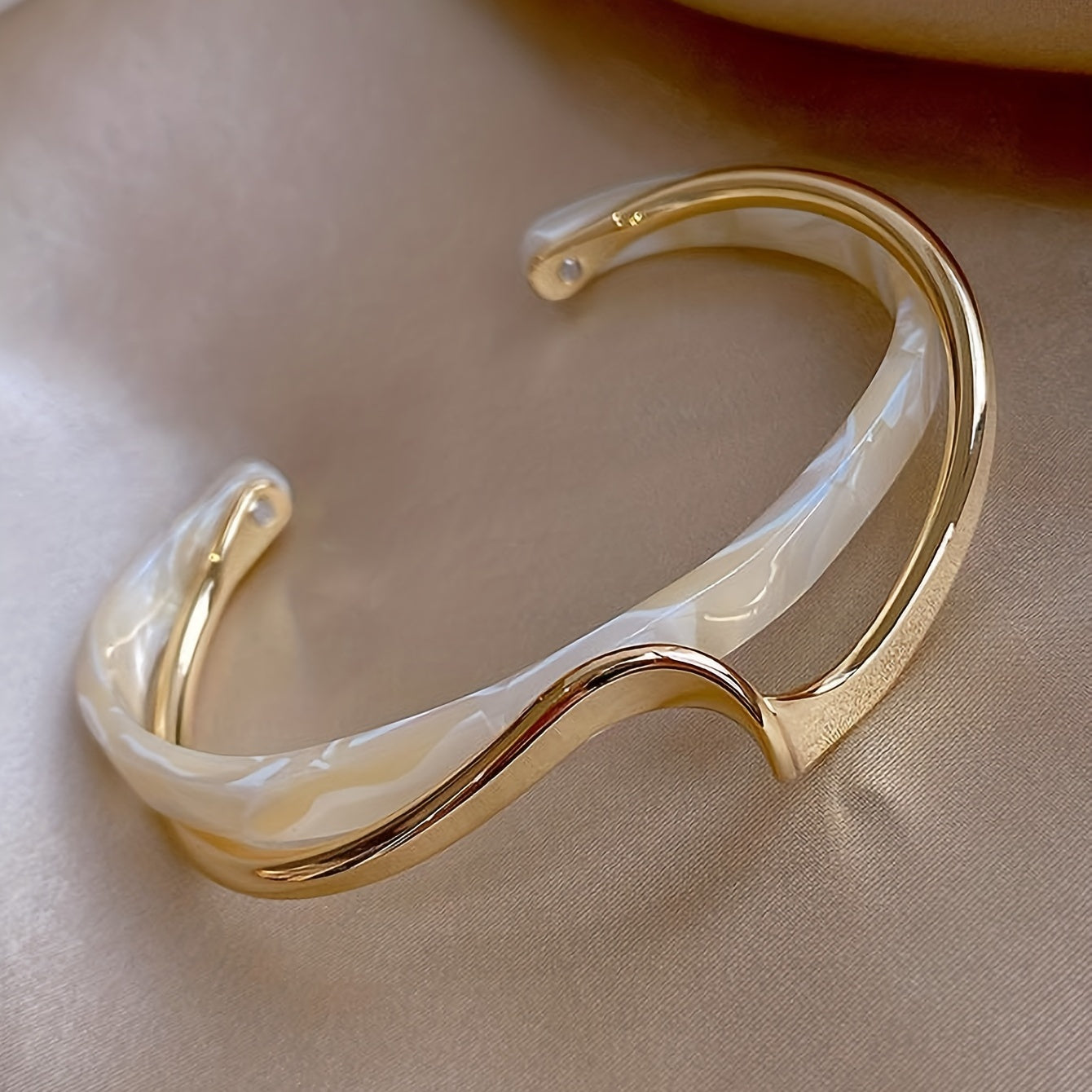 Wave-shaped cuff bangle with faux pearl inlay, featuring a minimalist style in 18K gold plating, ideal for women's jewelry collection