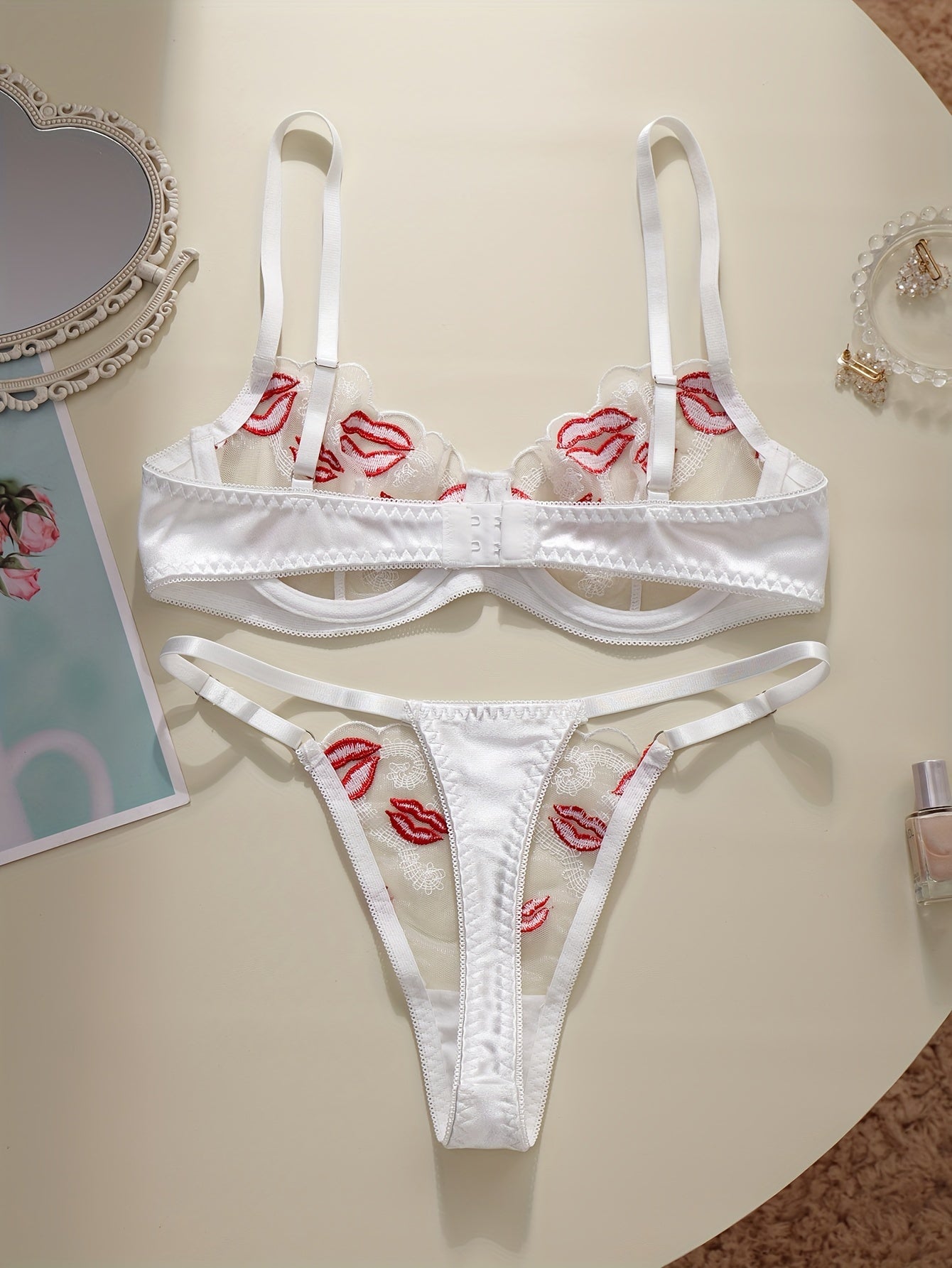 Floral embroidered lingerie set with sexy lips pattern, made of polyester knit fabric. Includes a geometric-patterned bralette and thong, no padding.