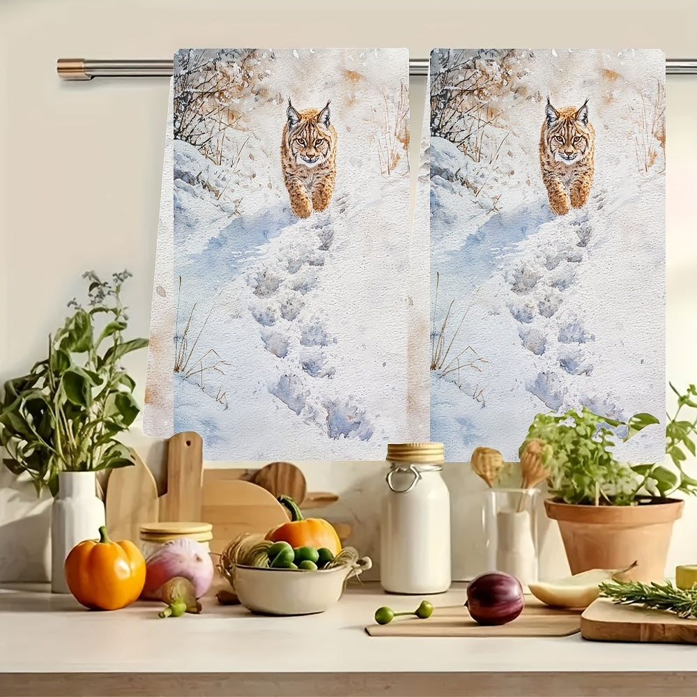 Two pieces of Lynx Snow Footprints kitchen towels, made of super absorbent polyester knit fabric. These towels are machine washable and feature a contemporary coastal style, measuring 40.64x60.96 cm. They are perfect as dish hand towels for holiday decor.