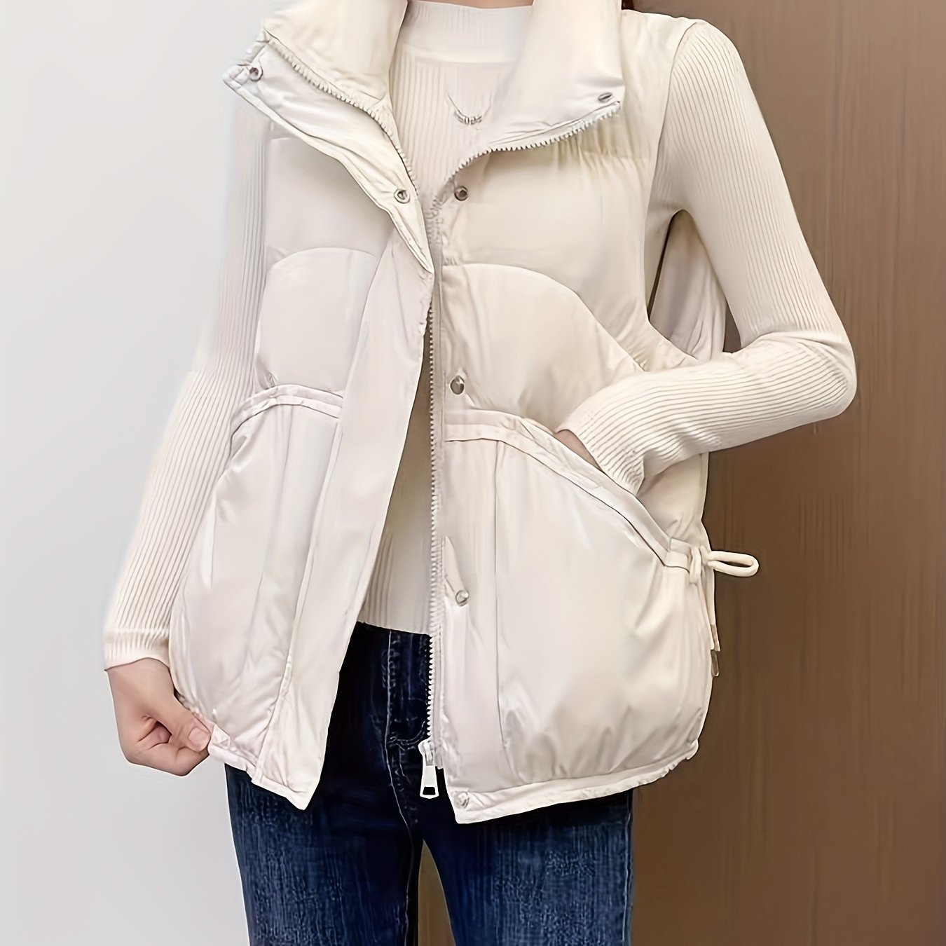 Waterproof sleeveless puffer vest in solid cream color with zippered pockets, perfect for casual daily wear.