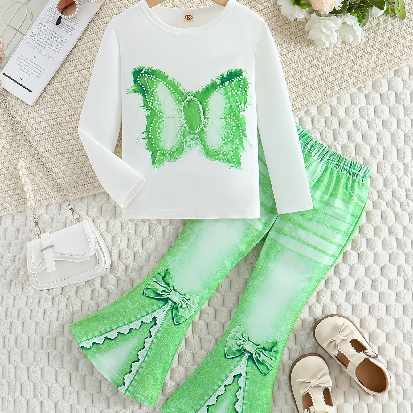 Girls' outfit set includes a long sleeve top with butterfly print and flared faux denim pants with a bow detail. Made of slight stretch knit fabric with an animal pattern, this regular fit