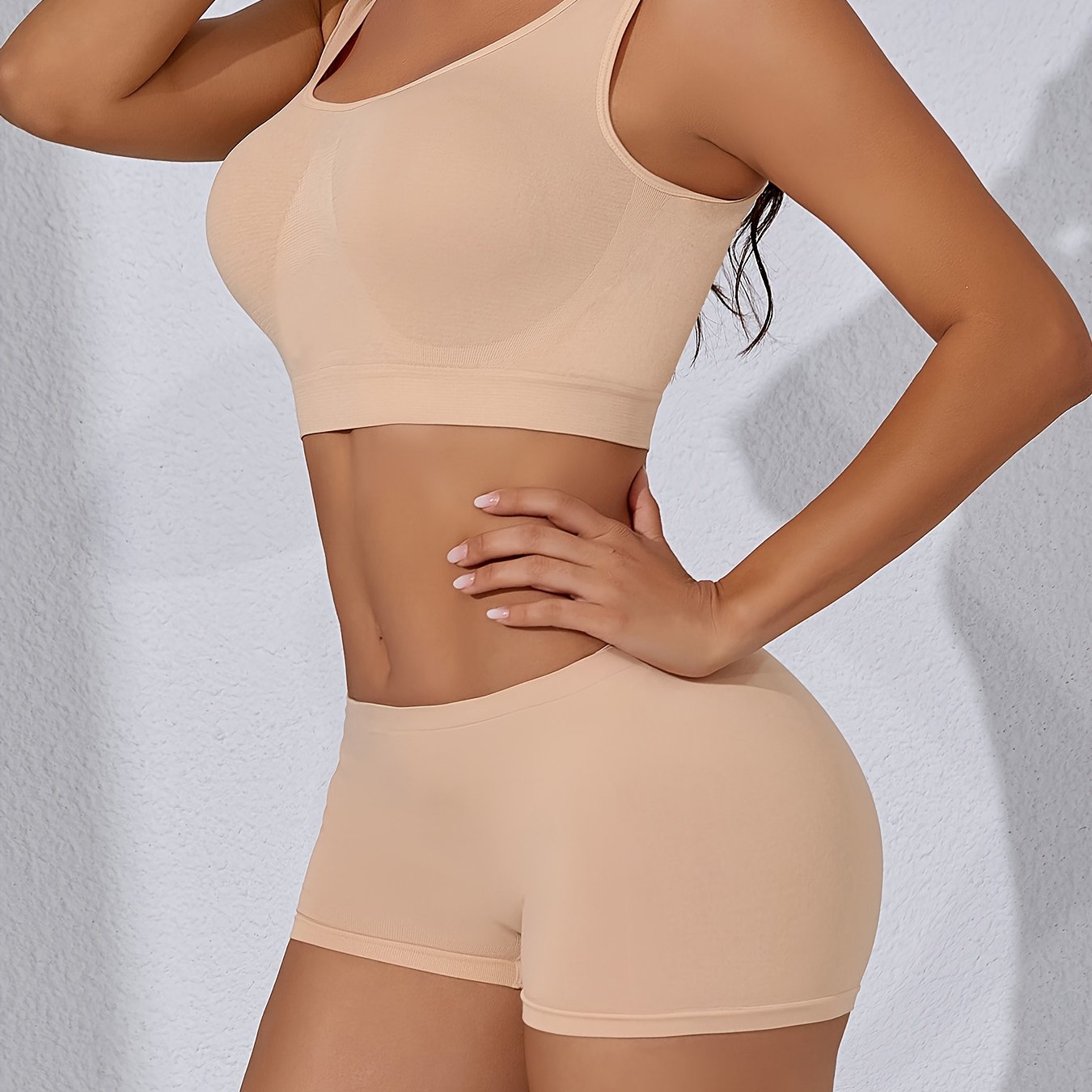 Seamless sports bra and high-waisted shorts set in breathable nylon with spandex blend, wire-free and padded, solid color casual adult pajama set.