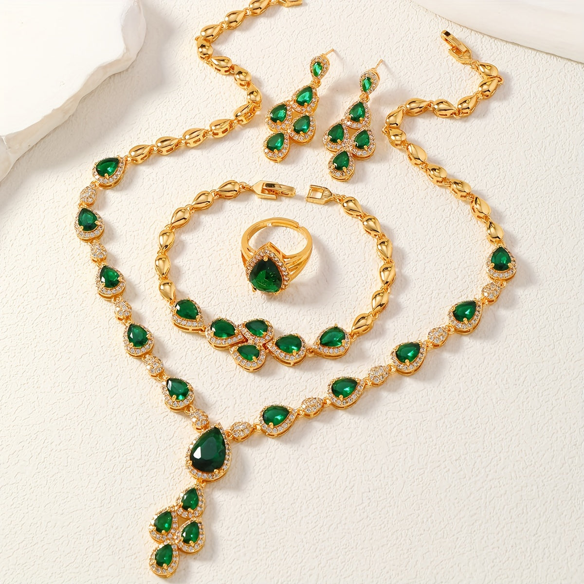 A set of four pieces of stunning Middle Eastern women's wedding jewelry from Saudi Arabia, featuring full inlay peacock green water drop-shaped cubic zirconia on copper. The set includes one necklace, one bracelet, one ring, and one pair of earrings.