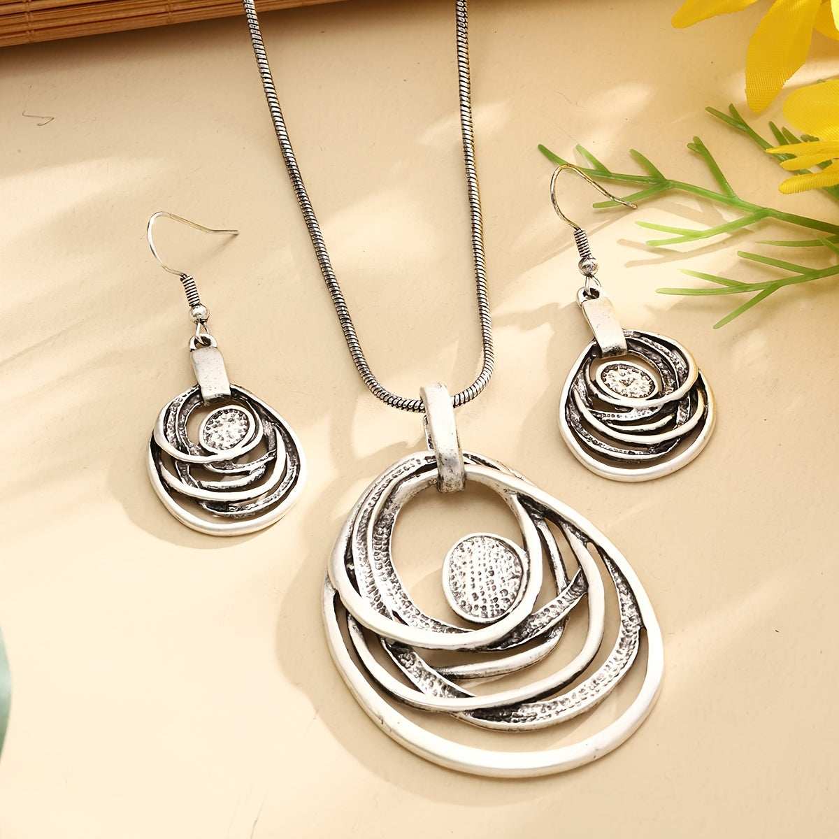 This set includes a pair of earrings and two necklaces made of zinc alloy in an ancient silvery color. The necklaces feature a multi-layer circular mosaic design with a retro bohemian style and a hollow center. This leisure jewelry set is perfect as a