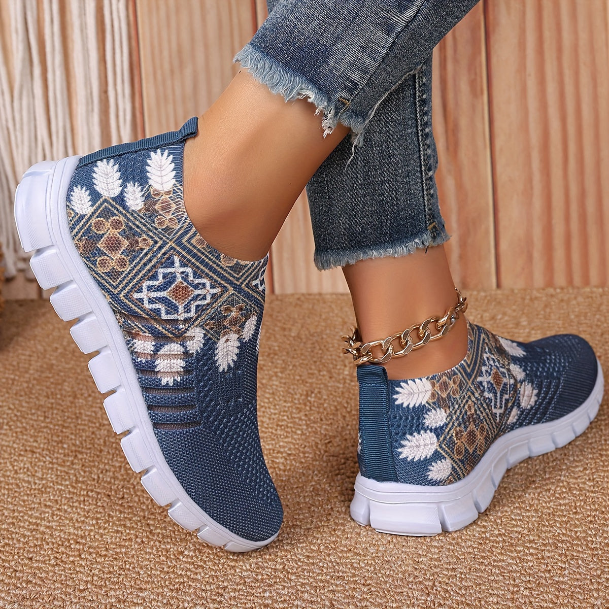 Women's casual slip-on sneakers in blue knit fabric with white floral and geometric patterns, featuring a lightweight EVA sole and breathable low-top design. Perfect for everyday wear with