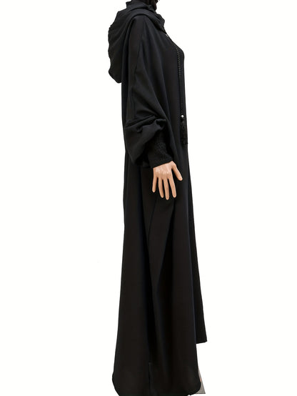 Elegant black abaya with batwing sleeves, drawstring hood, and loose fit. Versatile minimalist style for all seasons. Made of polyester.