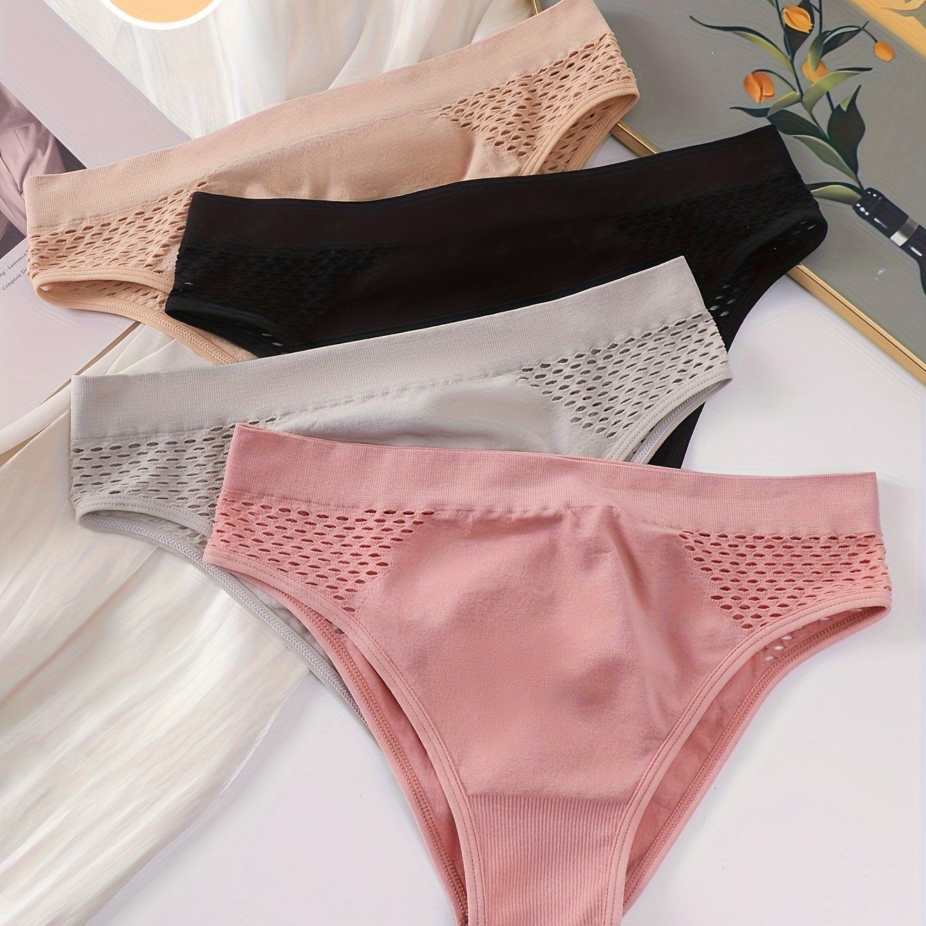 Four-pack of low-rise briefs for women, with hollow-out design and medium support. Made from a blend of 90% Polyamide and 10% Elastane knit fabric, in a solid color. Lightweight at 200gsm