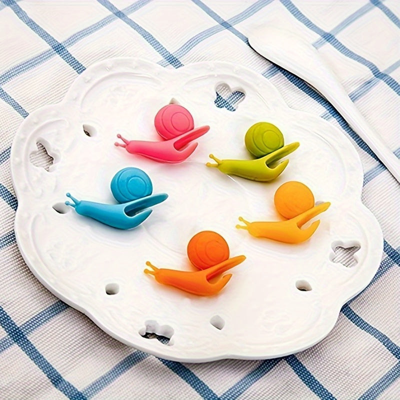 A collection of 8 silicone tea bags designed in the shape of adorable snails, along with macaron tea cups, hangers for tea bags, unique snail-shaped tea bag strings, racks for tea bags, and identifiers for cups. These silicone kitchen gadgets are ideal