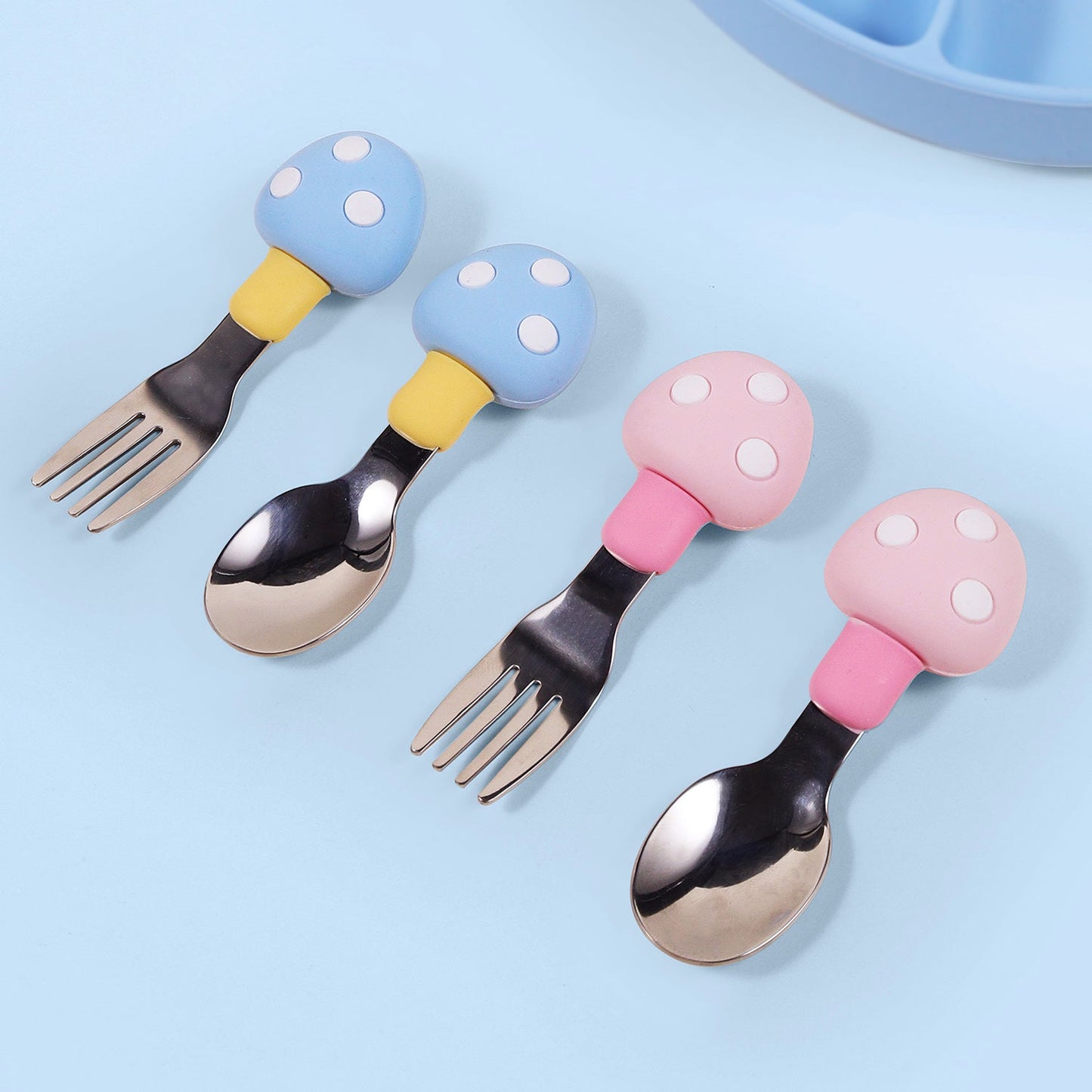 Set of feeding utensils for babies made of silicone and featuring a mushroom design. Includes a spoon and fork.