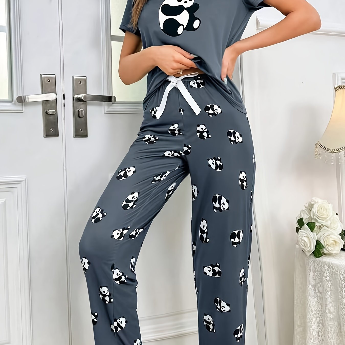 Women's sleepwear set with cute panda print, short sleeve top, and elastic pants.