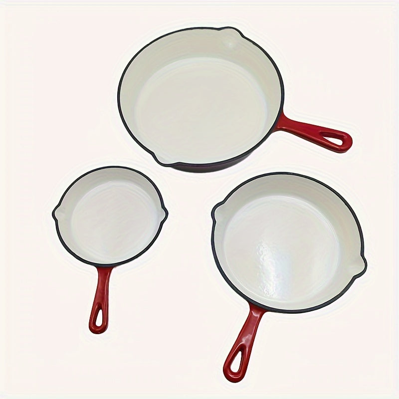 Set of three enamel-coated cast iron skillet in red and cream colors, with sizes of 15.24cm, 20.32cm, and 25.4cm. Can be used on stovetop and in the oven.