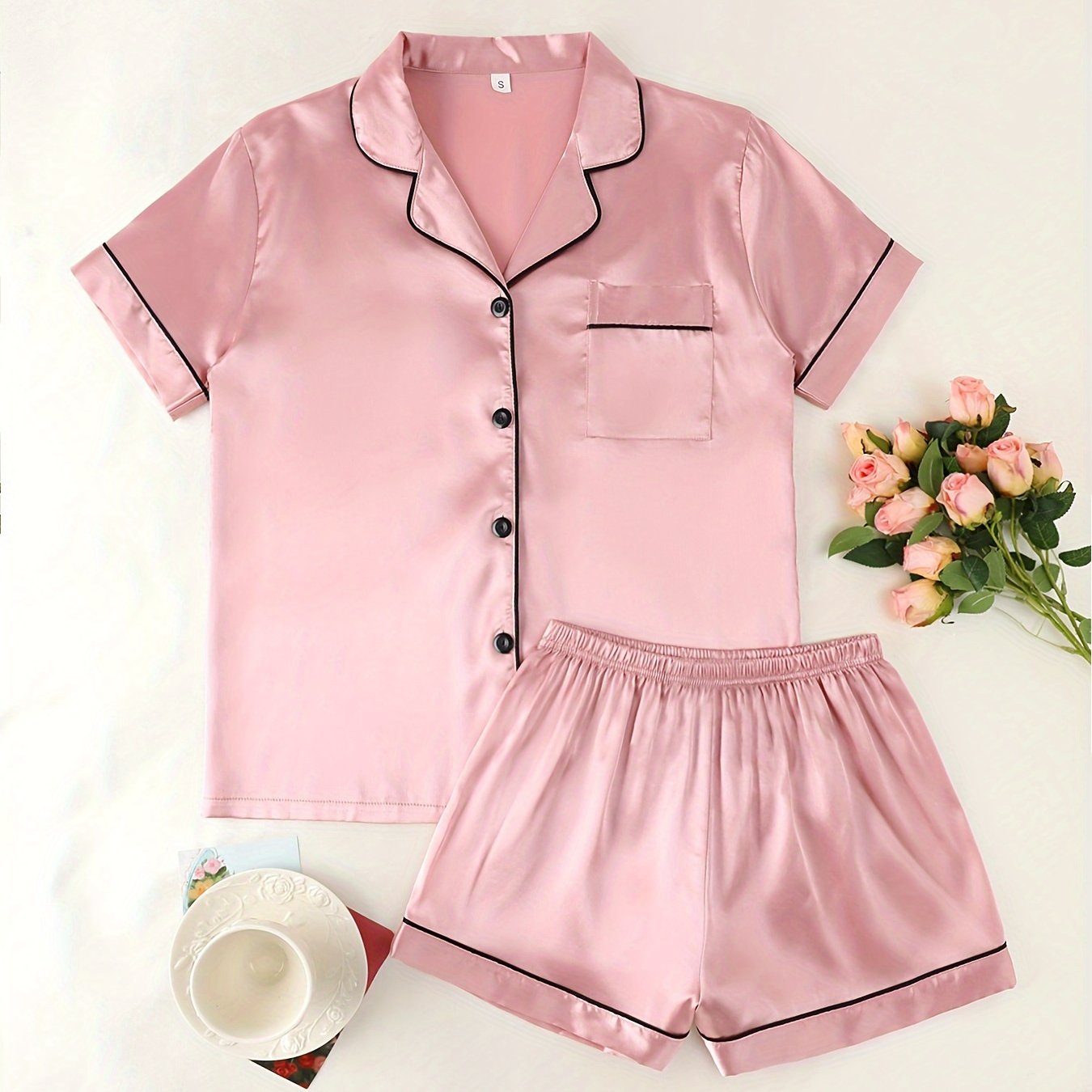 Women's satin pajama set with short-sleeve top and button-up shorts.