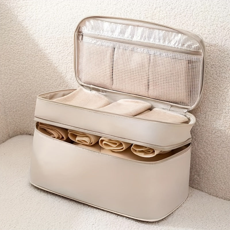 Travel underwear and bra organizer bag with double-layer design and divided compartments. Made of beige polyester fabric with a mesh interior. Ideal for dorms, trips, and daily use. Hand