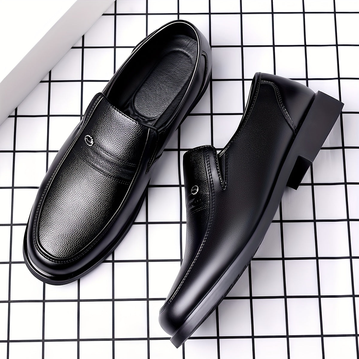 Black slip-on loafers for men featuring a rubber sole, round toe, and embossed logo - perfect for casual attire.