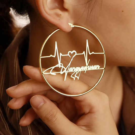 Unique set of personalized heartbeat earrings - Stylish and alluring gold-toned stainless steel hoop earrings measuring 70mm, featuring a custom handwritten design. Perfect for both casual and formal occasions, these trendy earrings are an essential