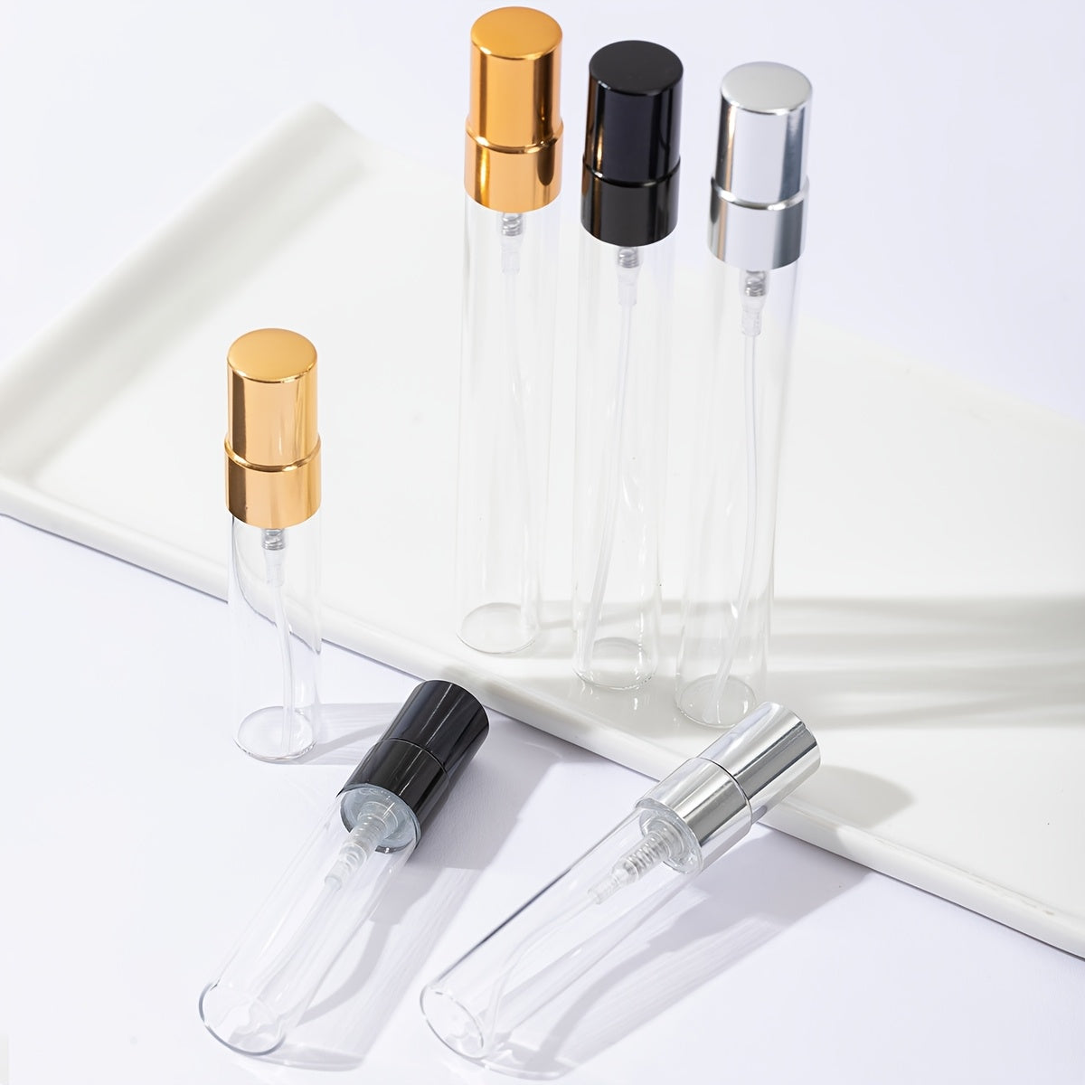 50 transparent glass bottles for decanting 5ml and 10ml perfumes, with spray tops.