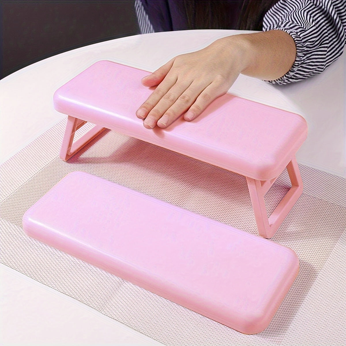 Single folding nail armrest for manicurists, with hand support and wrist rest for salon use.