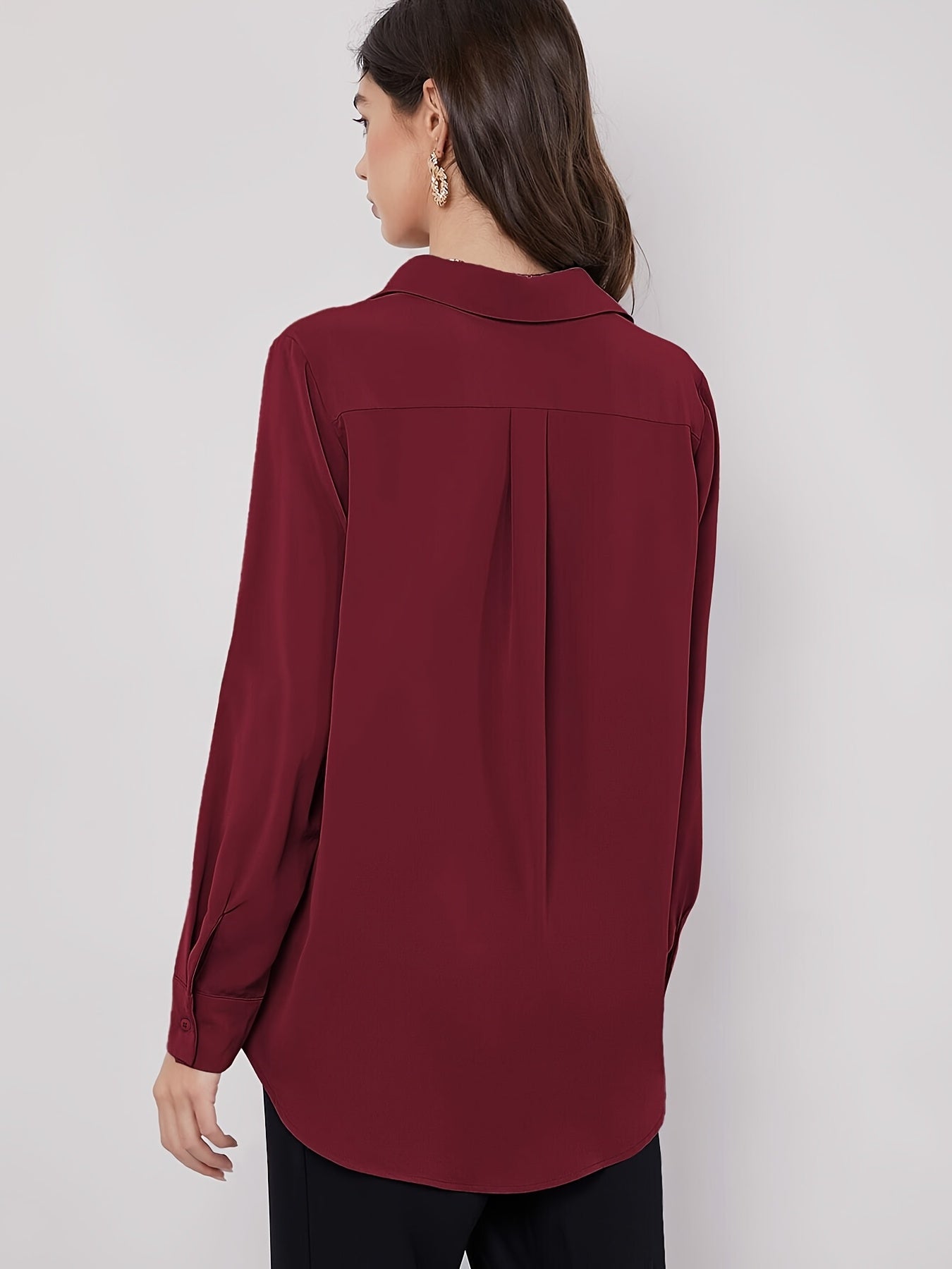 Stylish maroon button-up blouse for women, with long sleeves, curved hem, and made of machine-washable polyester blend. Perfect for work or casual wear.