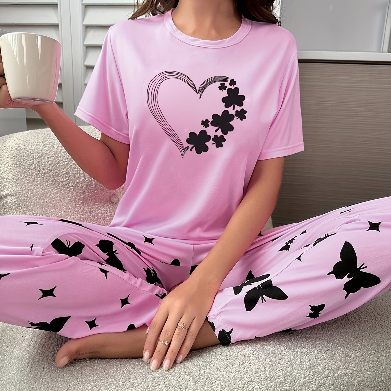 Short-sleeve top and shorts set with hearts, butterflies, and four-leaf clovers pattern, for sleepwear and loungewear.